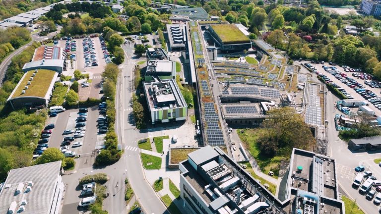 Aerial view of Penryn Campus buildings with solar panels and green roofs, illustrating the site of the new heat‑pump upgrade.